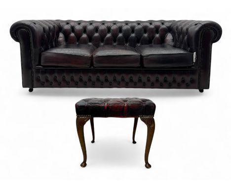 Chesterfield three-seat sofa, traditional shaped upholstered in deeply buttoned dark red leather; together with similar foots