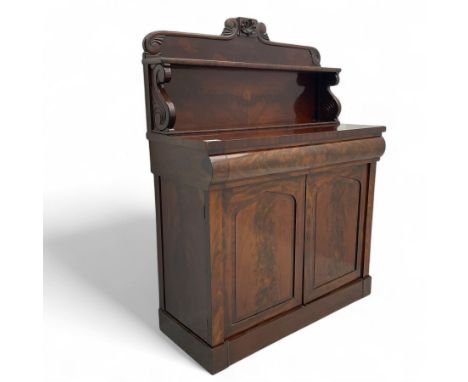 Victorian mahogany chiffonier, projecting scroll-carved cresting rail with central shell motif above a single shelf back, pla