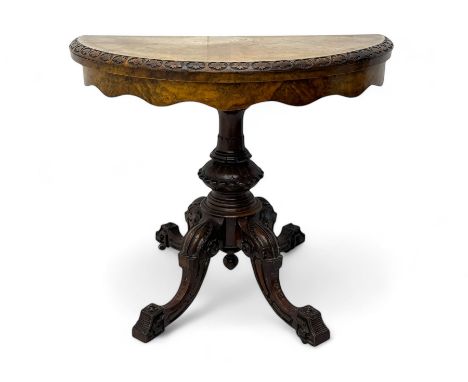 Victorian walnut demi-lune card table, circular fold-over top with foliate carved edge, revealing green baize-lined playing s