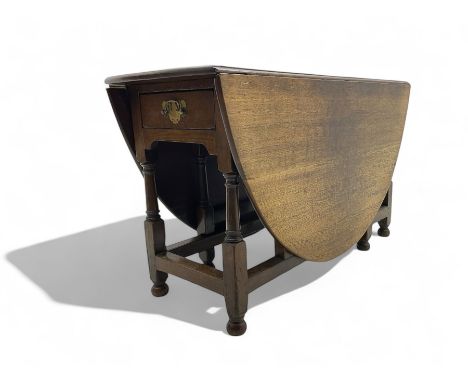 Late 19th to early 20th century oak dining table, oval drop-leaf top over single end drawer, gate-leg action base, on turned 