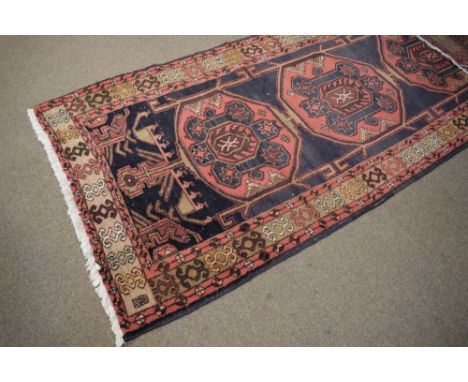 Mid to late 20th Century wool runner, the indigo field with three large guls, within multi borders, 305cm x 112cm  