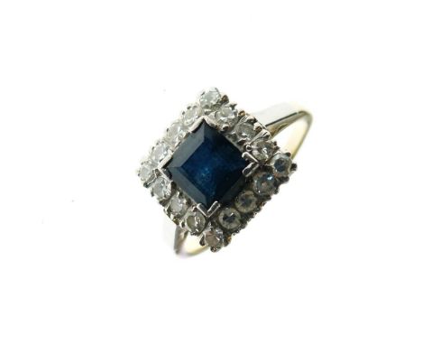 Yellow metal, platinum, diamond and sapphire dress ring, with central square sapphire within sixteen small diamonds, shank st