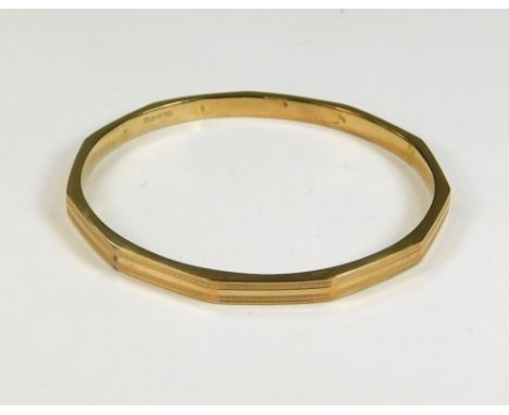 GOLD BANGLE. An Art Deco 9ct. gold, engine turned slave bangle. Chester 1927. Approx. 8.5g.