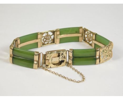 JADE BRACELET. A Chinese green jade bracelet with 14k. Chinese character clasp.