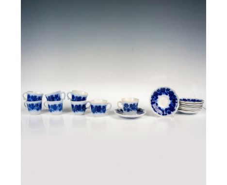 Eight charming teacups with matching saucers, adorned in a delicate flow blue floral design, scalloped edges, and ribbed embo