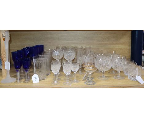 A collection of table glassware, including a part suite of cut crystal drinking glasses with faceted stems and star cut bases