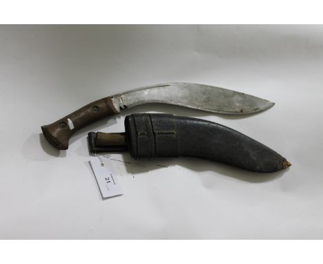 A MILITARY KUKHRI. A WW11 period military issue Kukhri, complete with its scabbard and solitary knife. The 12.3/4" blade stam