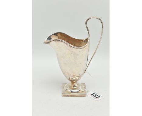 AN EDWARDIAN BRITANNIA STANDARD SILVER HELMET SHAPED CREAM JUG, beaded rim, strap handle, short pedestal and square foot, mak