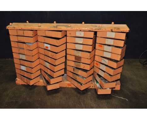 A VINTAGE METAL HARDWARE CADDY with four banks of nine swinging trays width 69cm depth 10cm height 40cm