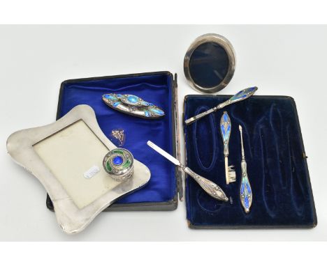 TWO SILVER PHOTO FRAMES AND AN INCOMPLETE MANICURE SET, the first an early 20th century, polished wavy rectangular photo fram