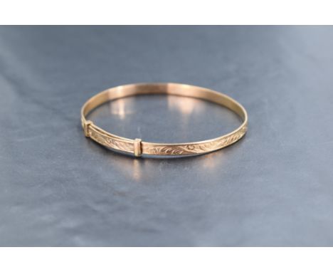 A 9ct rose gold slide clasp bangle of slim form having engraved decoration, approx 7.6g
adult size approx 60mm x 50mm interna