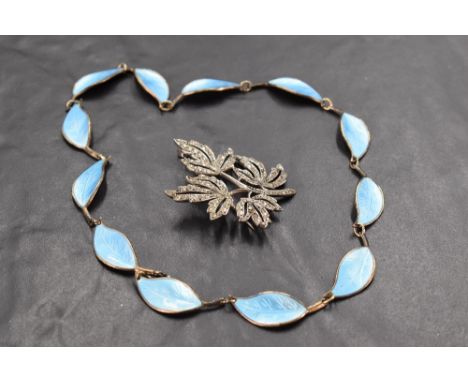 A Norwegian silver and turquoise enamel leaf necklace by David Anderson and a white metal foliate diamante brooch stamped ste