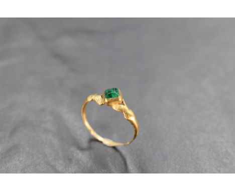 A 17th Century Jacobean gold and emerald fede ring having central emerald in collared mount with shoulders modelled as hands 