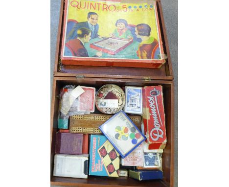 A collection of games and playing cards, in a wooden box 
