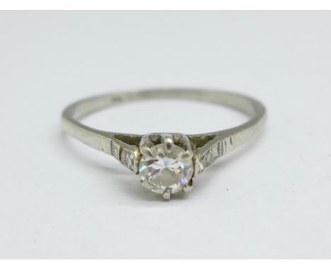 A white metal and diamond solitaire ring also set with four square diamonds, centre stone approximately 0.25carat weight, 2.6