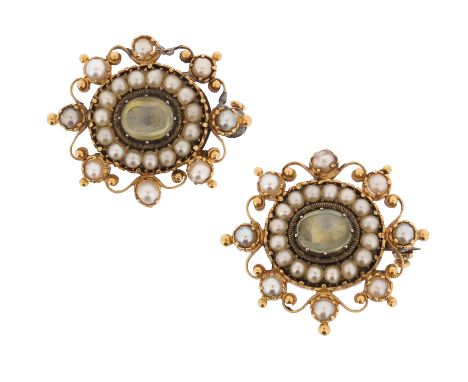 A pair of early 19th century chrysoberyl and seed pearl-set gold brooches, set in scroll mounts with pellet decoration in gol