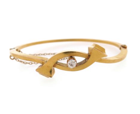 A late 19th century diamond-set gold hinged bangle, the top section composed of a pair of interlocking nailhead motifs each c