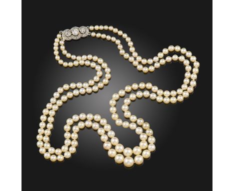 A two-row natural pearl necklace, the pearls graduate from 3.2 - 7.1mm, with a diamond-set platinum cluster clasp, 45cm short