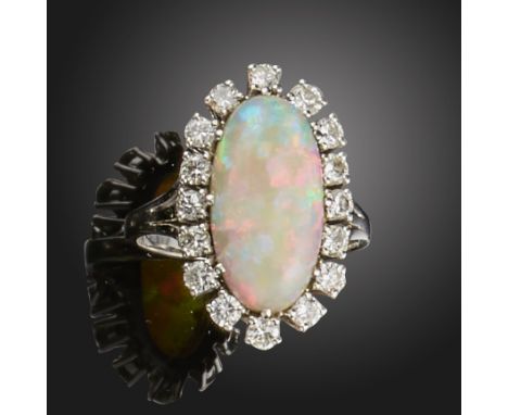 An opal and diamond cluster ring, the oval opal cabochon set within a surround of round brilliant-cut diamonds in white gold,