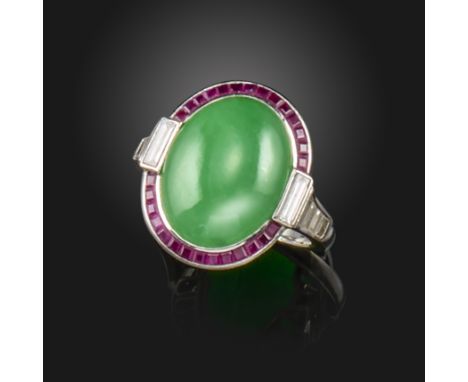 An early 20th century French jade, ruby and diamond ring, the oval jade cabochon set within a surround of calibr‚-cut rubies 