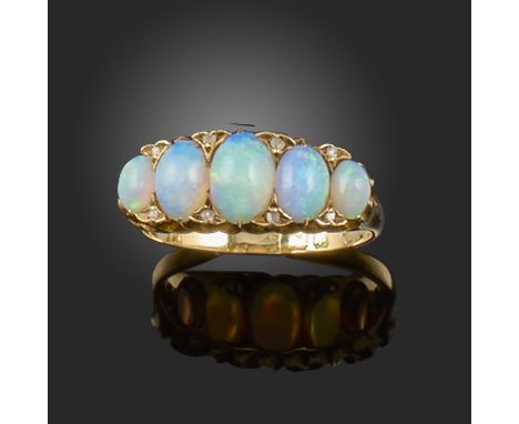 A late 19th century opal and diamond half-hoop ring, set with graduated opal cabochons and diamond pointers in gold, rubbed m