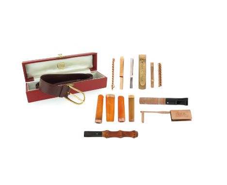 A three-colour 9ct gold textured cigarette holder with a Cartier box, four further cased cigar holders with gold ring-mounts;