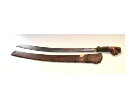 Indonesian sabre having carved wooden grip, in wooden sheath, blade approx 60cm long   Condition: Signs of rust to blade, the