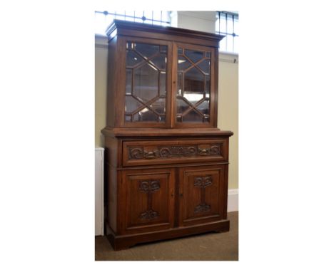 Early 20th Century Art Nouveau-style carved oak secretaire bookcase on cabinet, the upper section with bevelled glazed doors 