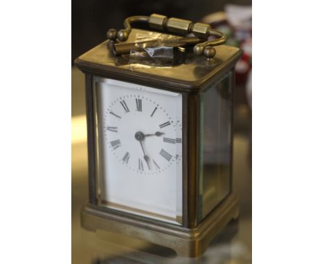A 20th Century brass bodied carriage clock with bevel edged glass panels and front.