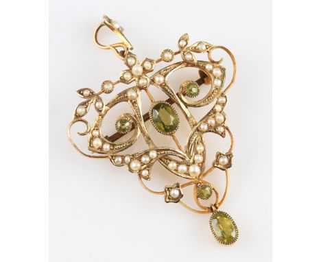 An early 20th Century 9ct yellow gold peridot and seed pearl pendant/brooch, in an open metalwork scroll and foliage design, 