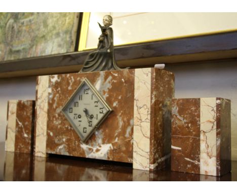 A pink and white marble Art Deco clock garniture, clock having metal seated female figure to top.