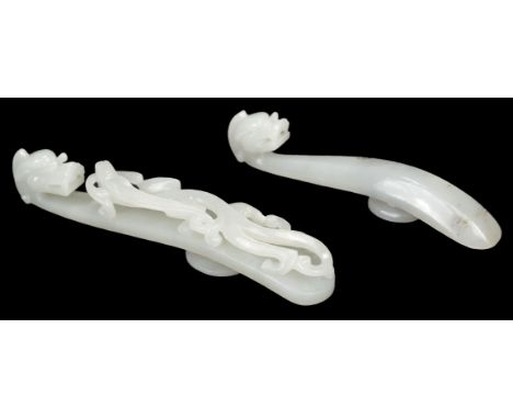 * Chinese Jade belt hook, the white stone carved as a dragon, 11.5 cm long, together with a smaller jade belt hook, similarly