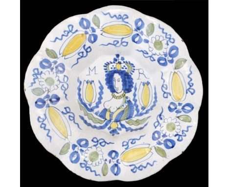 * Mary II delft charger, circa 1690, of lobed form, decorated in blue, green and yellow with a crowned half portrait facing l