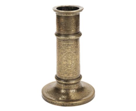 * A Persian brass candlestick, Qajar period (1789-1925), of cylindrical form engraved with panels of figures forming a narrat