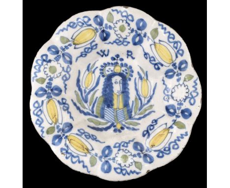 * William III delft charger, circa 1690, of lobed form and decorated in blue, green and yellow with a crowned half portrait f