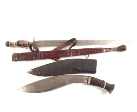 A kukri in its sheath with an ethnic short sword in leather scabbard