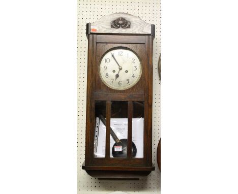 A 1930s oak drop trunk wall clock, with pendulum and winding key, height 75.5cm