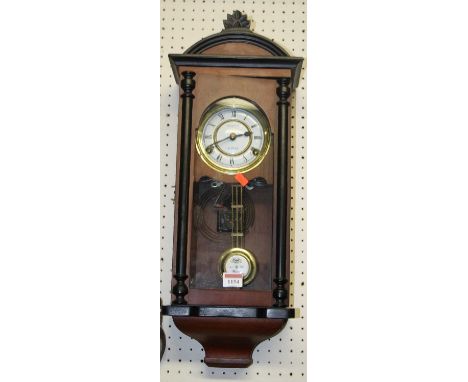 A contemporary mahogany drop trunk wall clock with pendulum