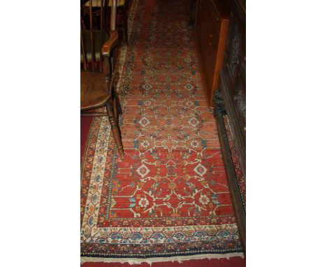 A Persian woollen red ground hall runner, having multiple trailing tramline borders, 420 x 115cmSee extra images.  Fading thr