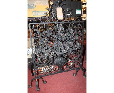 A Victorian black painted and floral decorated wrought iron firescreen