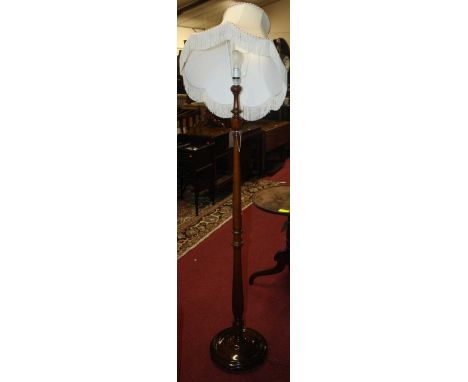 An early 20th century turned walnut standard lamp, with silk shade, height (excluding fittings) 153cm