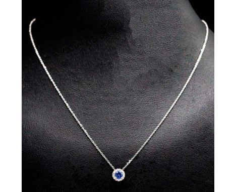 AN 18CT WHITE GOLD SAPPHIRE AND DIAMOND CLUSTER PENDANT. set with a round sapphire and round brilliant cut diamonds, on an 18