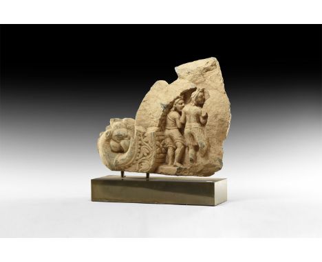 1st-2nd century AD. A carved schist frieze fragment with two figures and outline of a third, one wearing a pleated garment, s