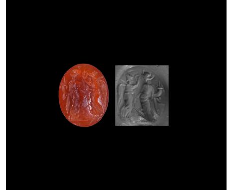 2nd-3rd century AD. An oval red carnelian intaglio gemstone engraved with Pax (Greek Eirene) holding a palm-branch and cornuc