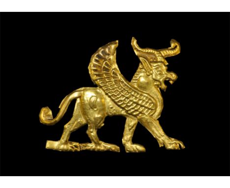 1st millennium BC. A repoussé gold foil mount in the form of an advancing winged bull with curved horns, gaping mouth, ellipt
