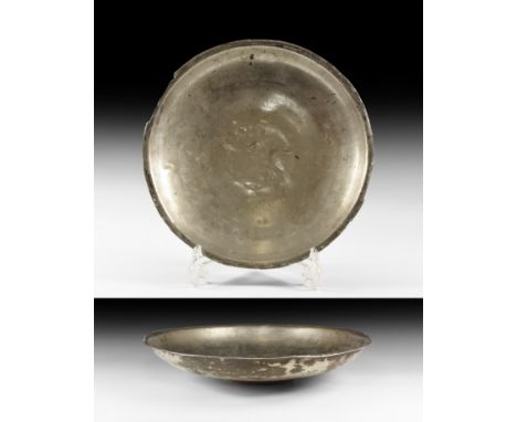 Eastern Empire, 2nd-4th century AD. A broad sheet silver dish with everted rim, low basal ring; pointillé inscription beneath
