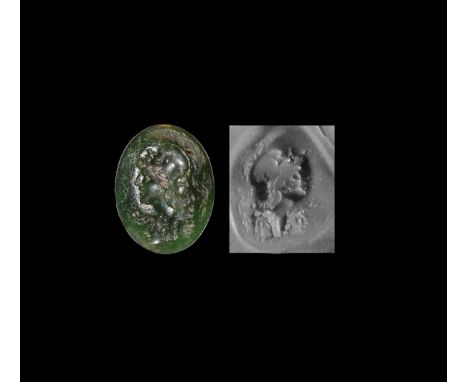 2nd-3rd century AD. An oval moss agate intaglio gemstone engraved with helmetted bust of Alexander the Great(?) facing left, 