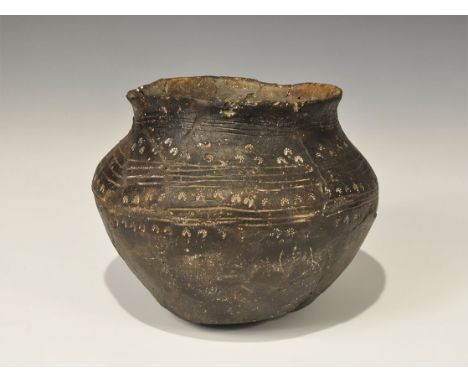 5th-6th century AD. A broad ceramic funerary urn, globular with broad sloping shoulder and irregular everted rim; circumferen