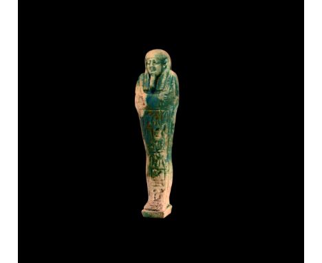Late Period, 664-332 BC. A glazed composition shabti with tripartite wig and false beard, tools in the crossed hands and seed