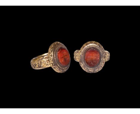 17th-18th century AD. A silver-gilt finger ring comprising a D-section hoop with median band of scrolled tendril ornament, el